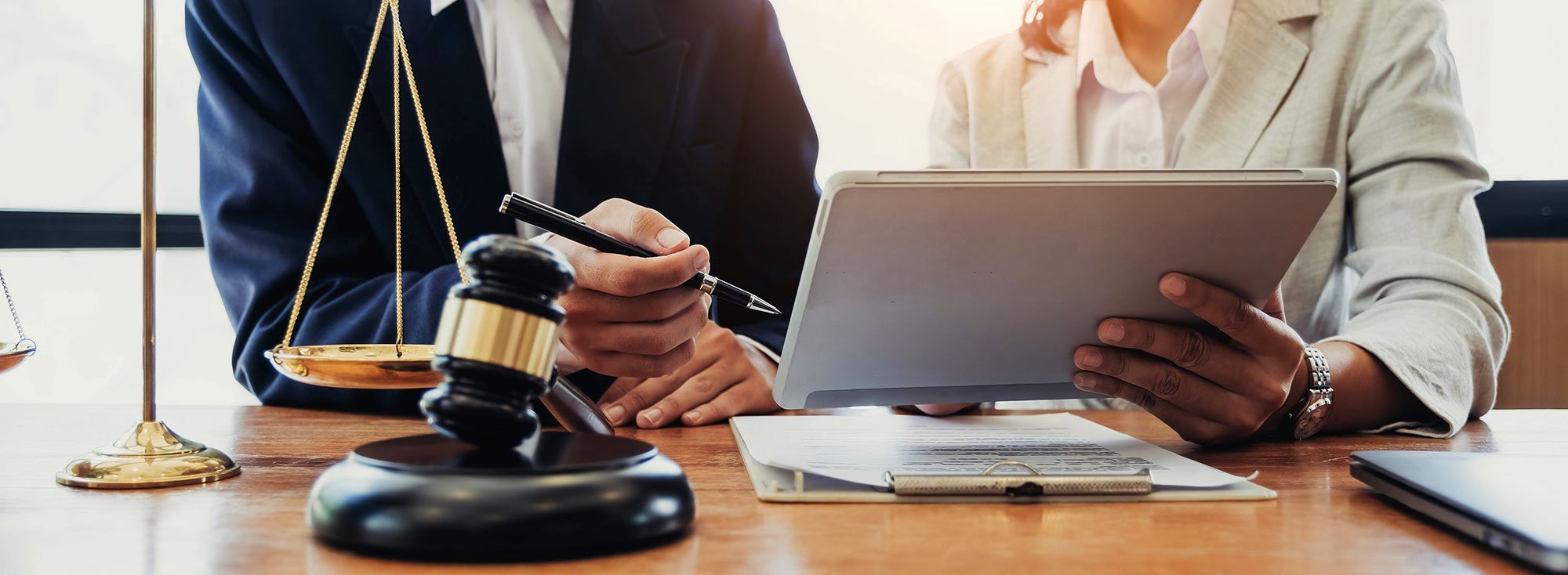 Close-up of two people reviewing legal documents at a table